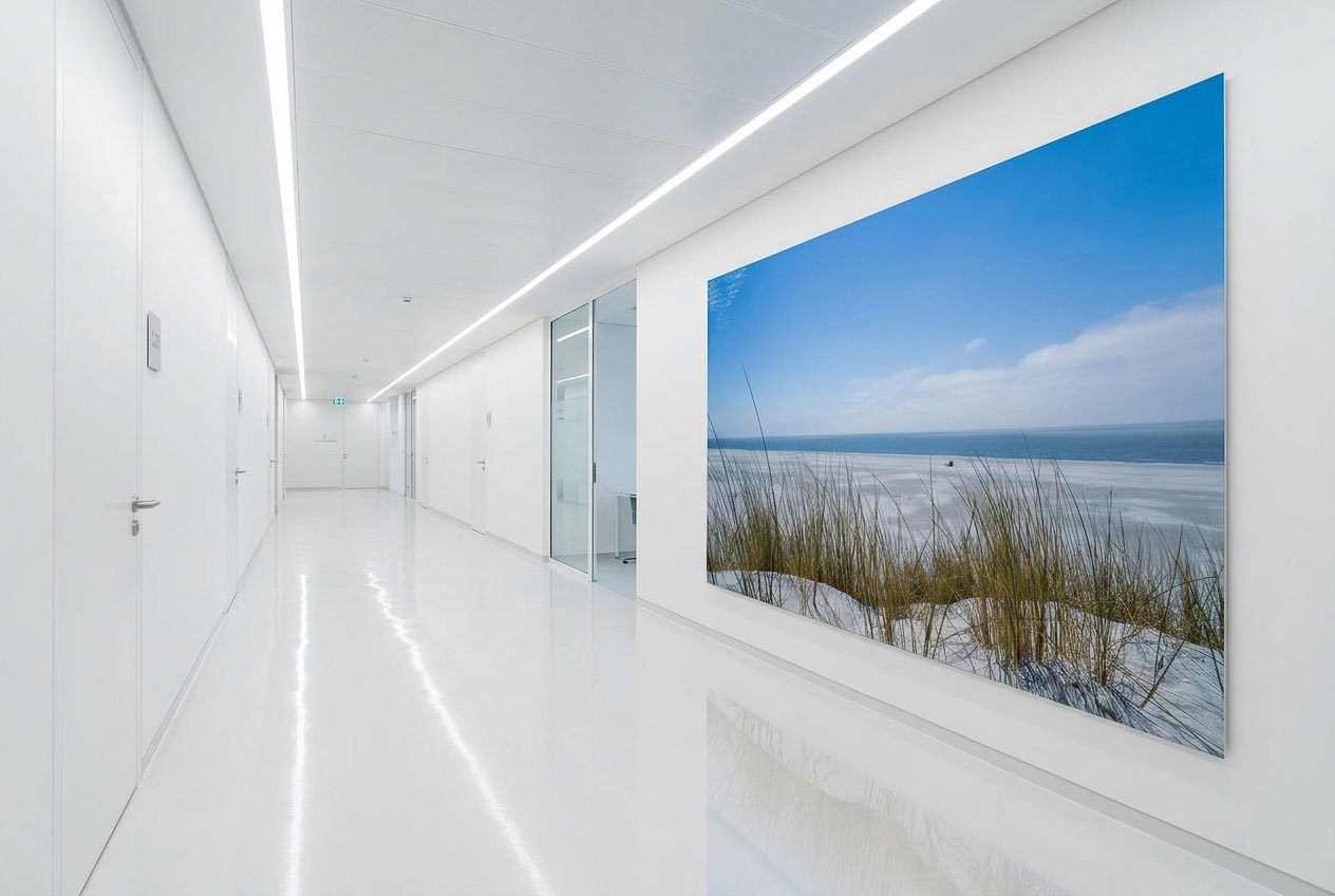 Wandgestaltung Bilder krankenhaus: XXL Panorama Wandbild mit Amrum Dünen und Blick über den Kniepsand zentral in einem hellen, weißen Flur.